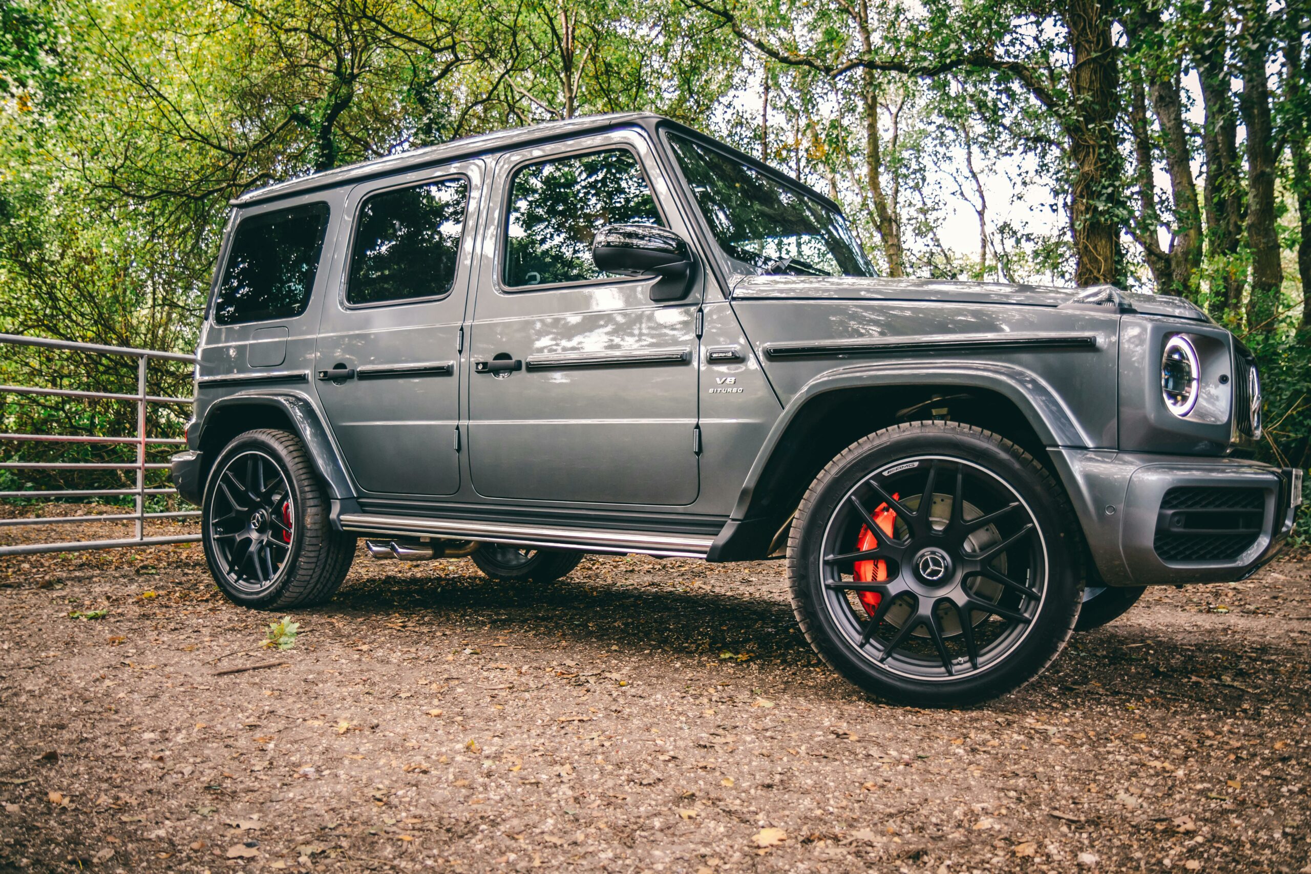 A luxurious Mercedes-Benz SUV parked in a scenic wooded area, showcasing elegance and power.